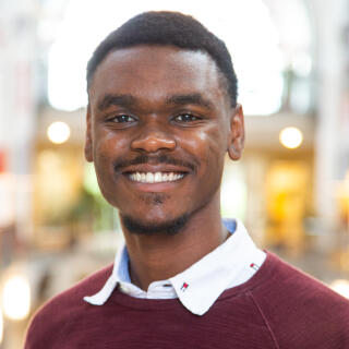 Profile photo of Christian Manning standing in the Great Hall of the Ohio Union