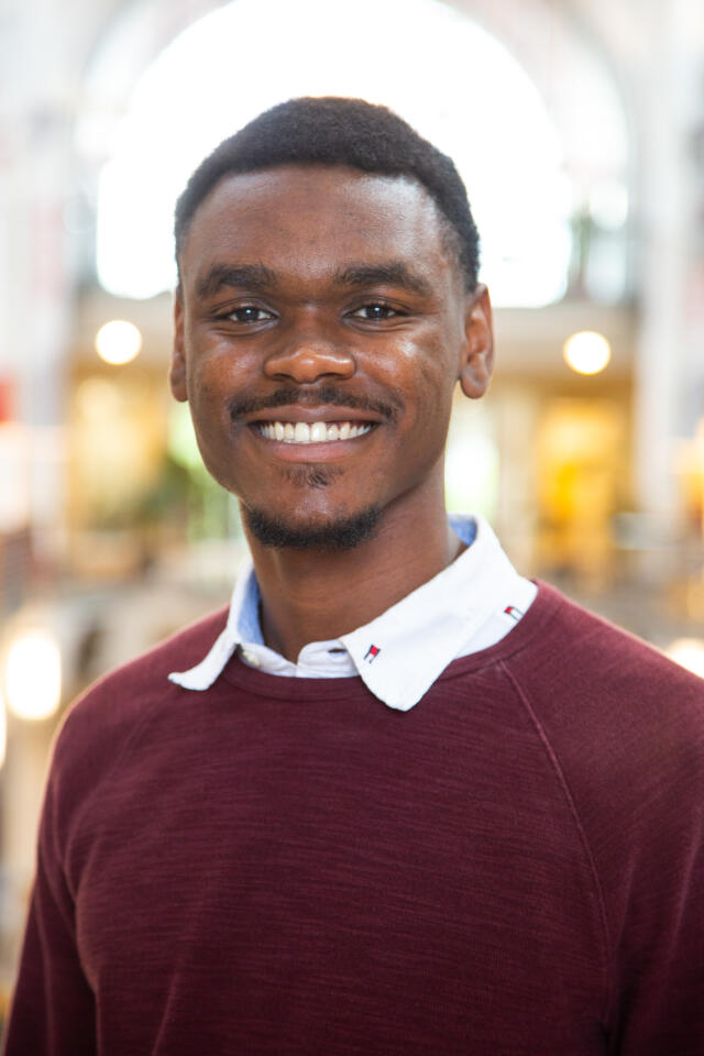 Profile photo of Christian Manning standing in the Great Hall of the Ohio Union